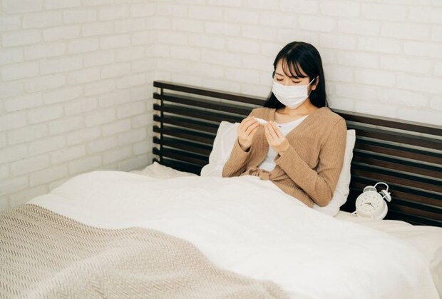 ベッドで休む体調不良の女性