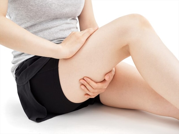 太ももを抑える女性