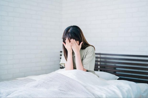 顔を手で隠す女性