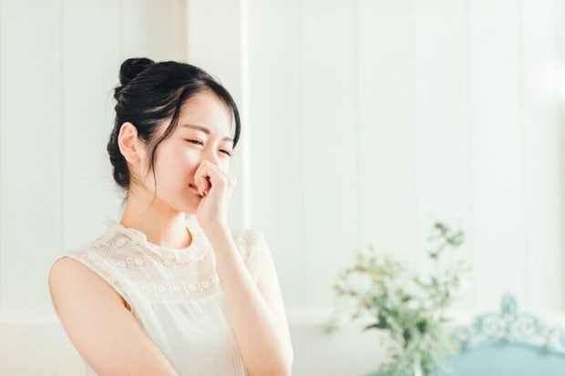 鼻を押さえる女性