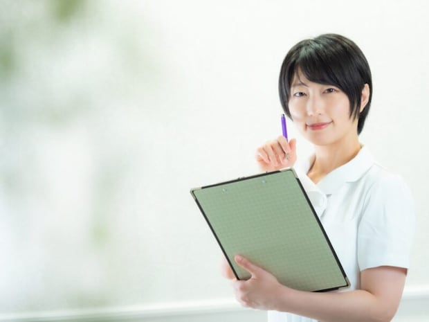 カルテを持つ白衣の女性