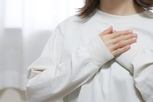 胸に手を当てる女性