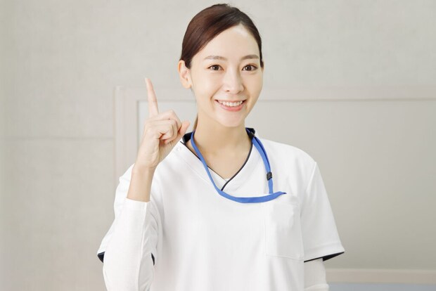 右手の人差指をたてる女性