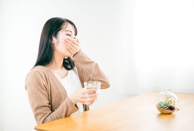薬を飲む女性