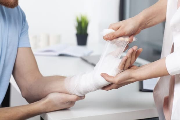 手首に包帯を巻いてもらう人