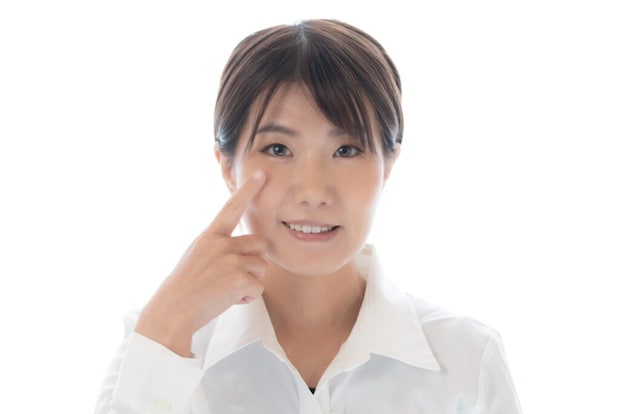 片目を指差す女性