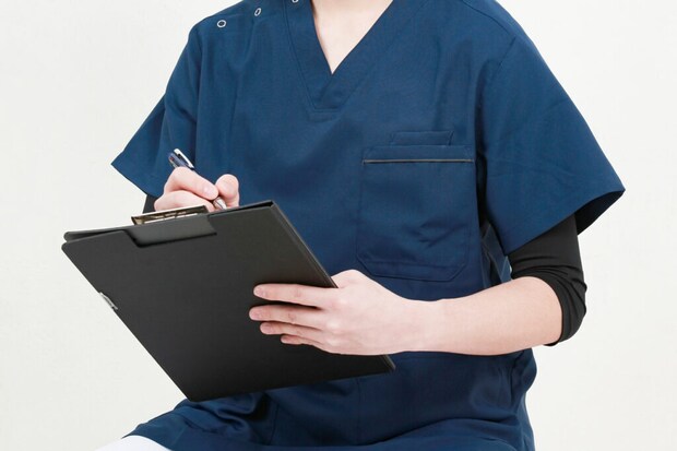 カルテに記入する男性医師