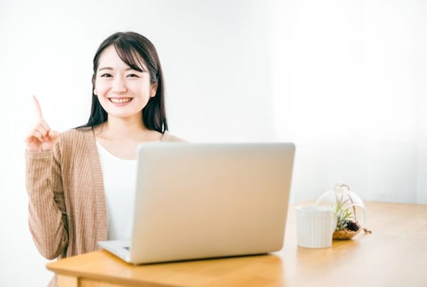 PCの前で笑顔の女性