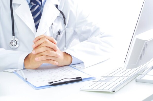 パソコンの前で話を聞く医者