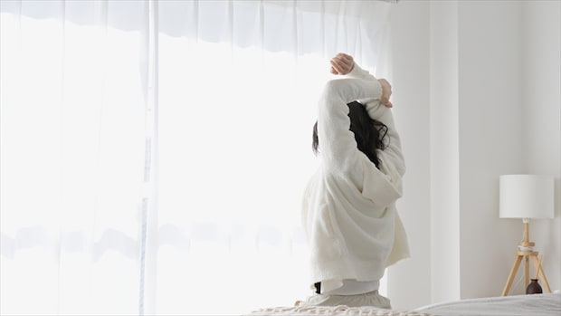朝起きて伸びをする女性