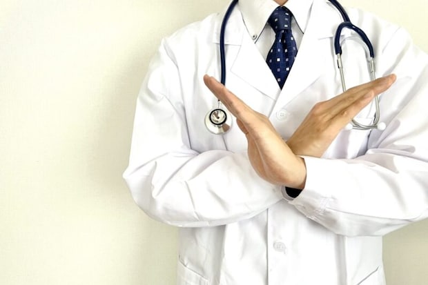 手でバツを示す医師