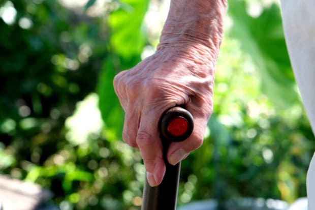 杖をつく高齢者の手