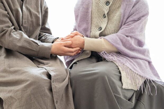 高齢の母の手を取る娘