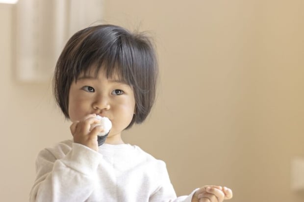 小さいおにぎりを食べる赤ちゃん