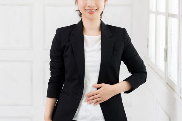 お腹に手を当てる女性