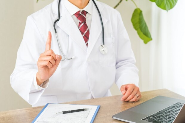 人差し指を立てるお医者さん