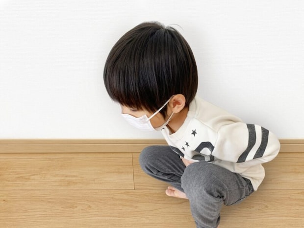 お腹をおさえてしゃがむ子