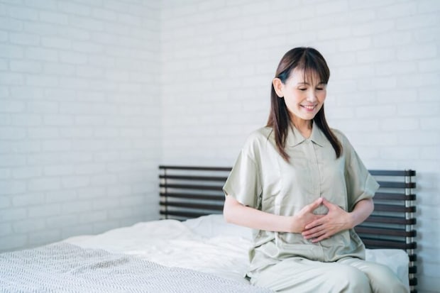 お腹を押さえる笑顔の女性