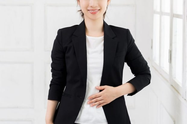 お腹に手を当てる女性