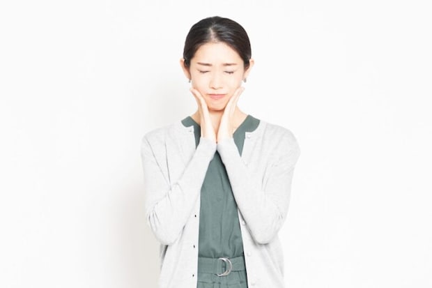 頬に手を当てる女性