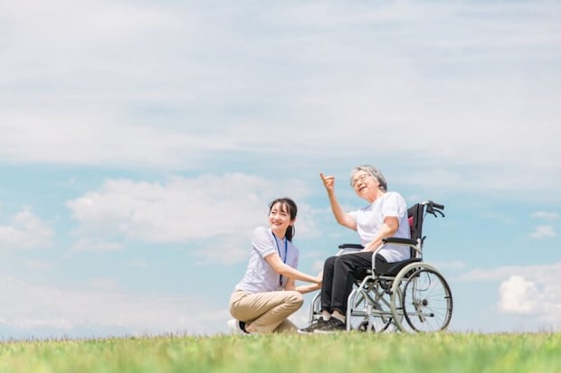 車いすの女性とヘルパー