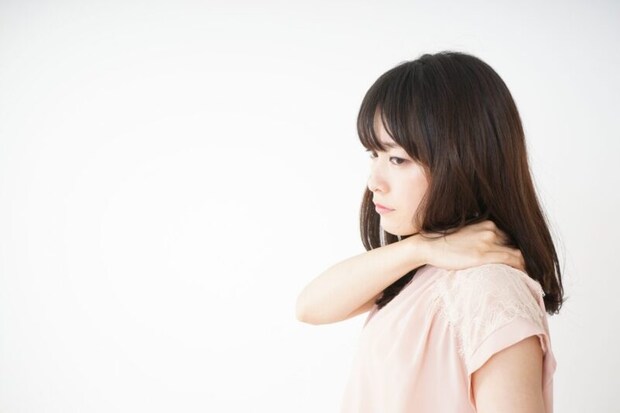 肩を押さえる女性