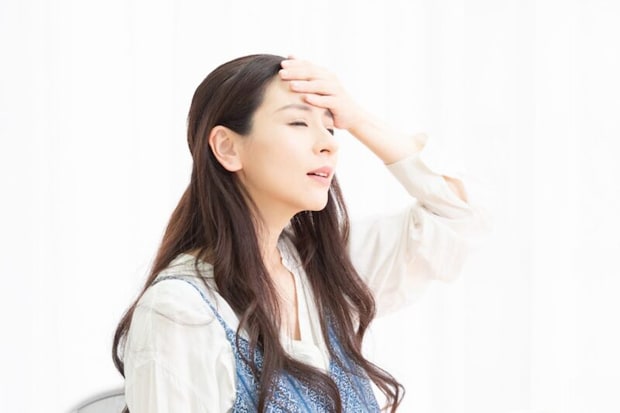 額に手を当てている女性