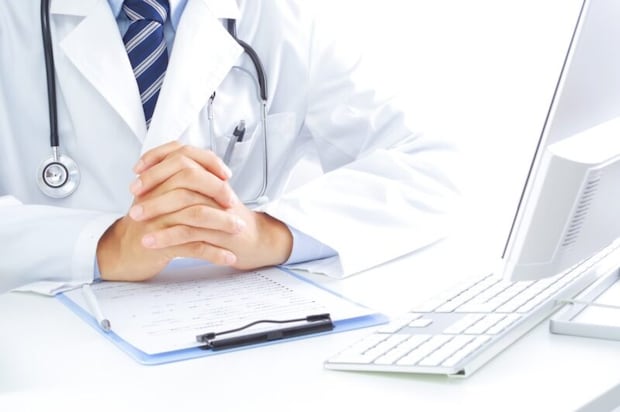 パソコンの前で話を聞く医者