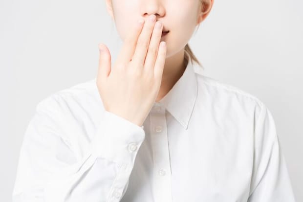 口元を抑える人