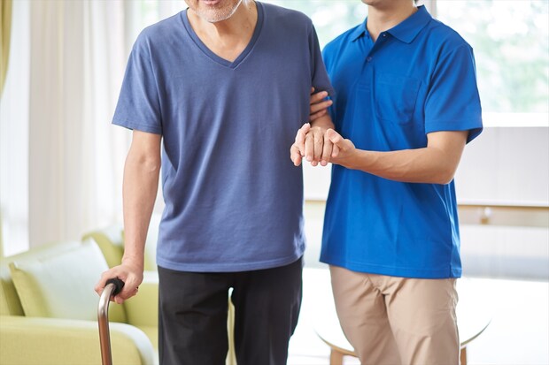 高齢者の歩行介助をする介護士