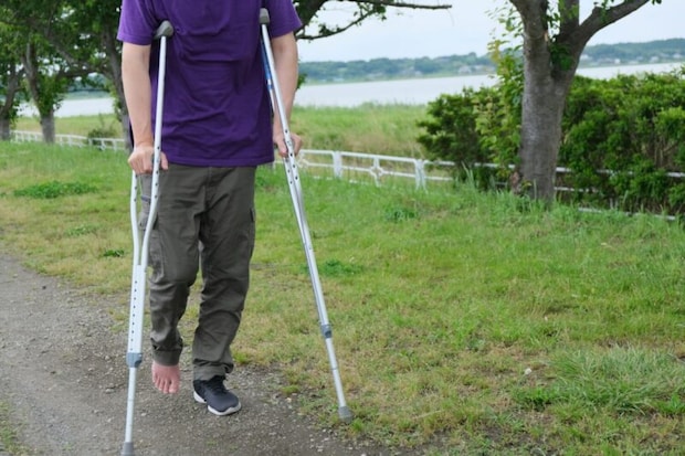 松葉杖を使って歩く男性