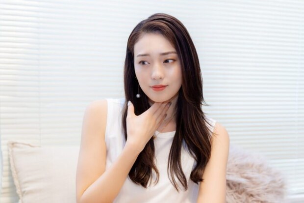喉に違和感を感じる女性
