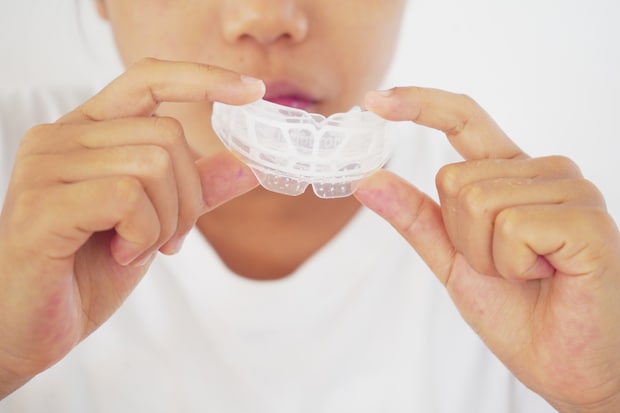 マウスピースを持つ子どもの手