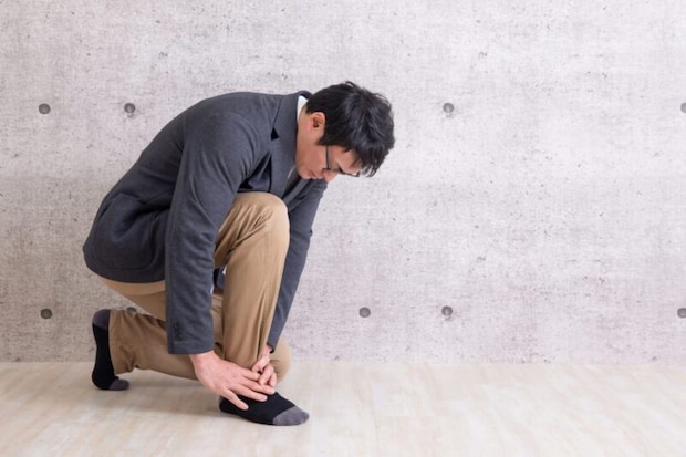 足を痛がる男性