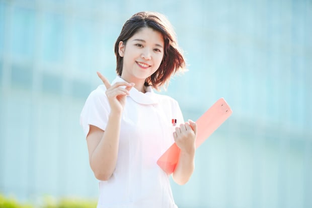 人差し指を立てる白衣の女性