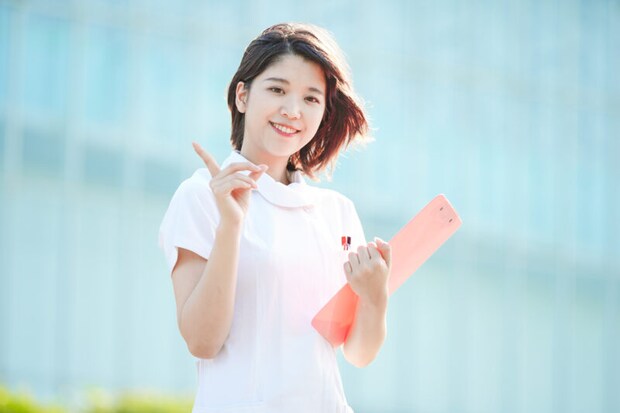 人差し指を立てる白衣の女性