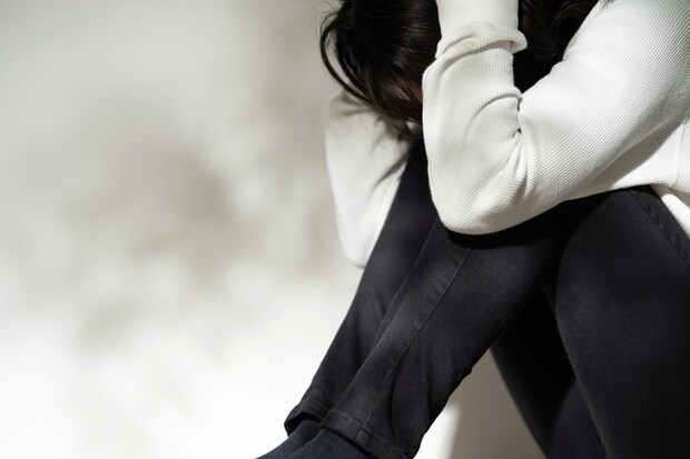 頭を抱え絶望する様子の女性