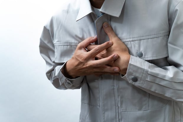 胸を押さえる男性