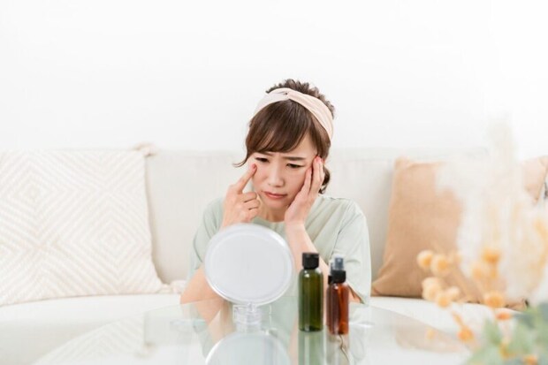 鏡を見て悩む女性