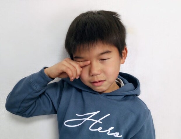 目をこする男の子