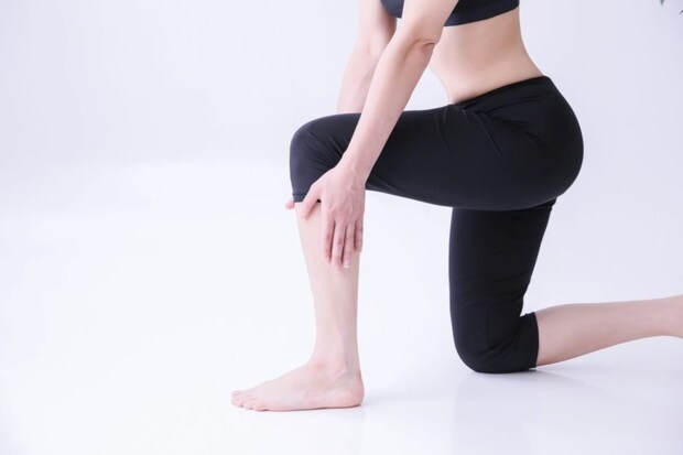 ふくらはぎを触る女性