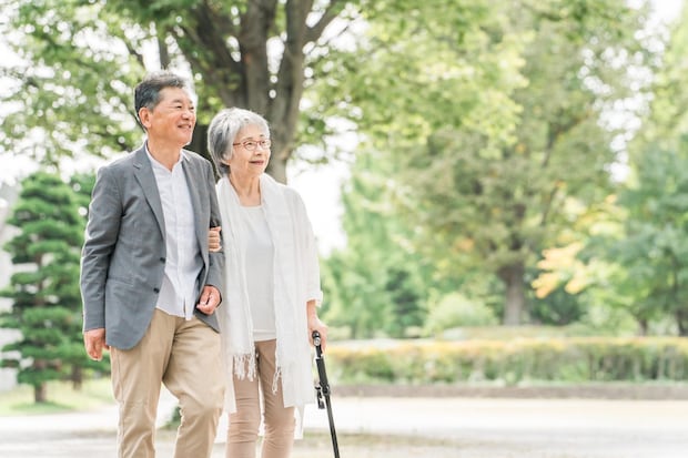 公園を話しながら歩く高齢者夫婦