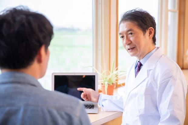 男性を診察する医師