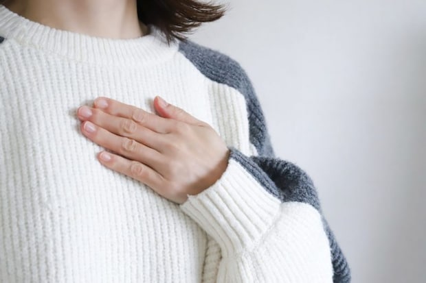 胸に手を当てる女性