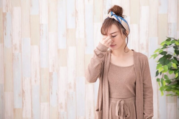 鼻根を押さえる女性