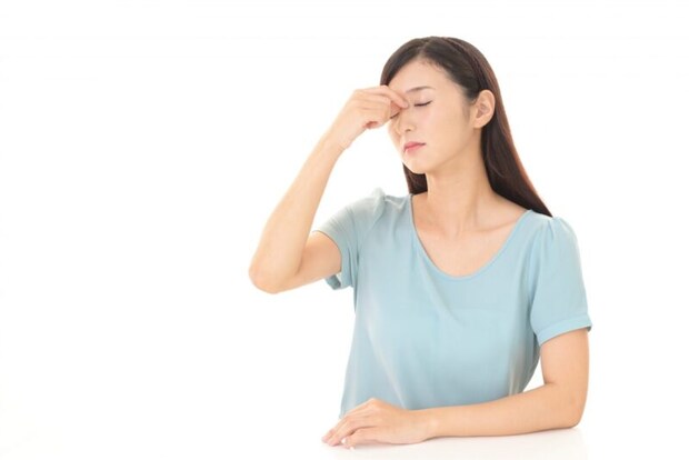 目頭を押さえる女性