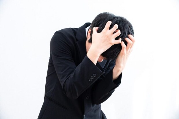 頭を押さえる男性