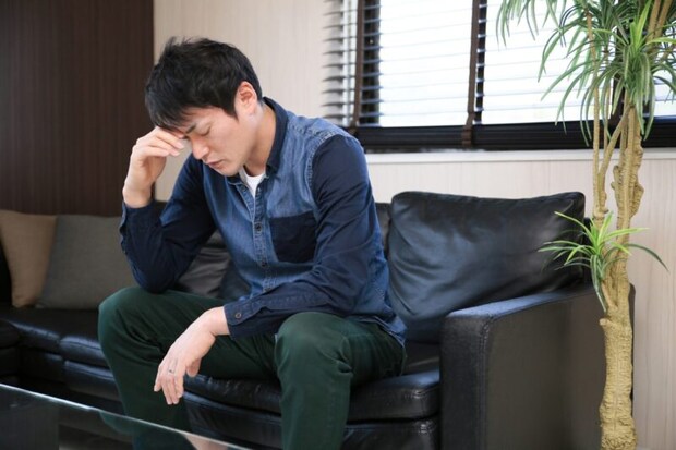 目頭を押さえる男性