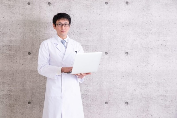 PCを持った白衣の男性