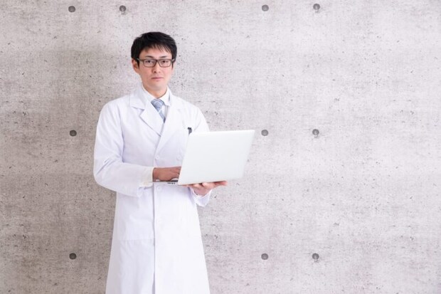 PCを持った白衣の男性